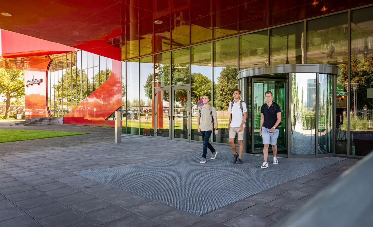 Drie studenten voor schoolgebouw