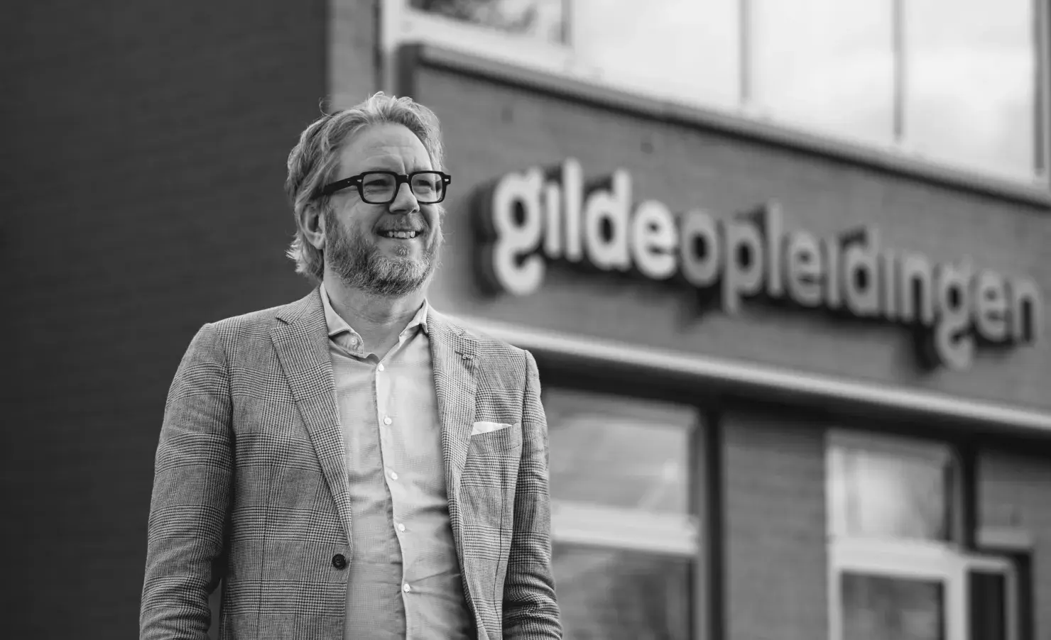 Man voor gebouw Gilde Opleidingen