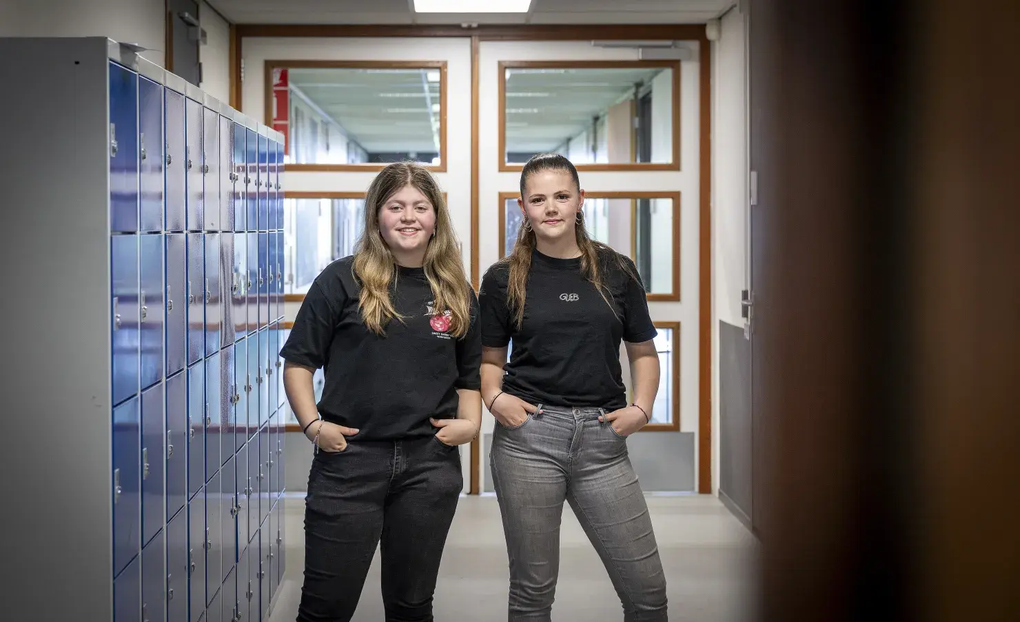 Twee meiden die poseren voor de kluisjes