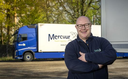 Man poserend voor vrachtwagen Mercuur Smart Logistics