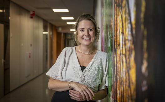 Vrouw leunend tegen muur, poserend voor de camera