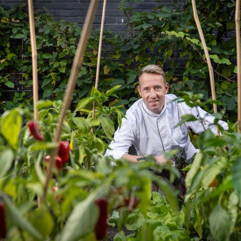Docent in moestuin van studenten
