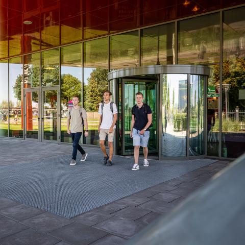 Drie studenten voor schoolgebouw