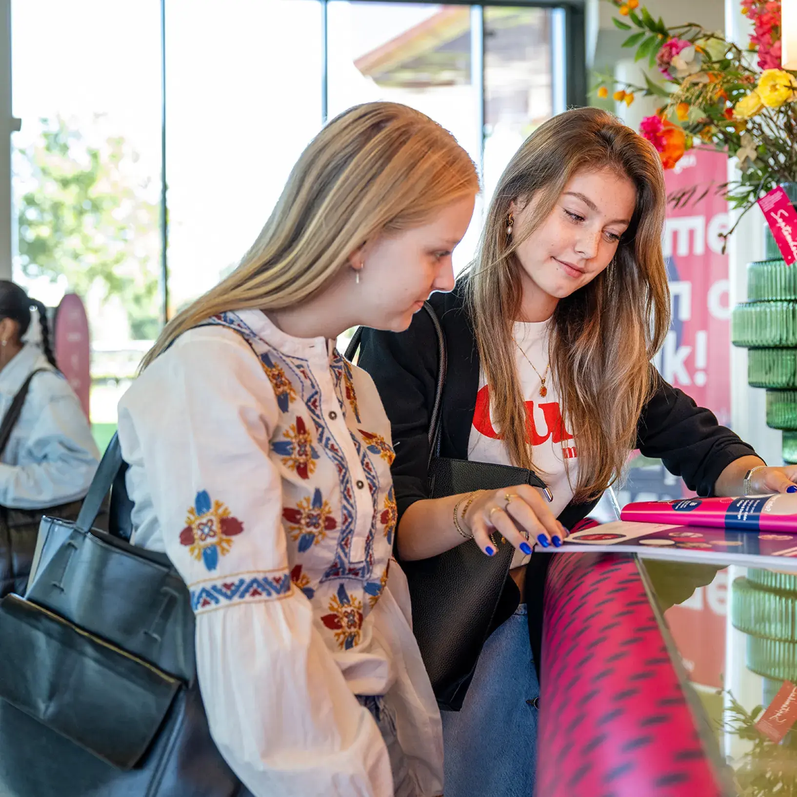 Studenten bij de receptie kijken in studiekeuzegids