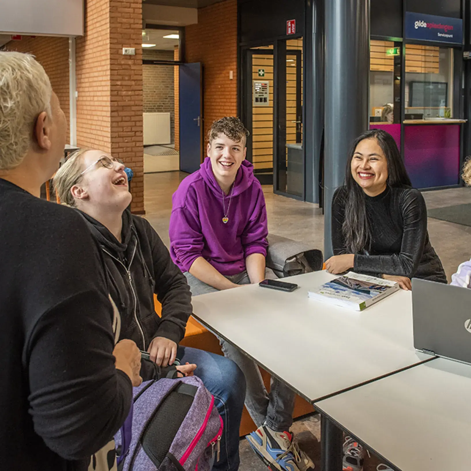 Docent en studenten lachend in kantine