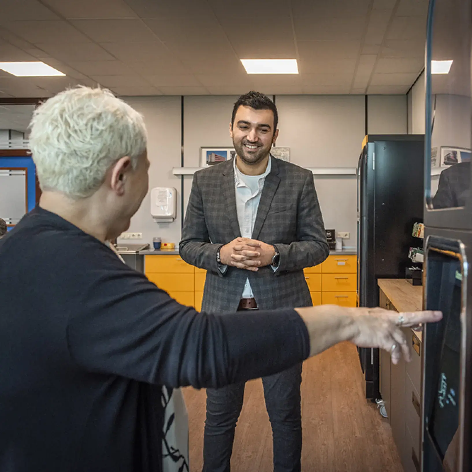 Twee collega's in de kantine bij de koffieautomaat