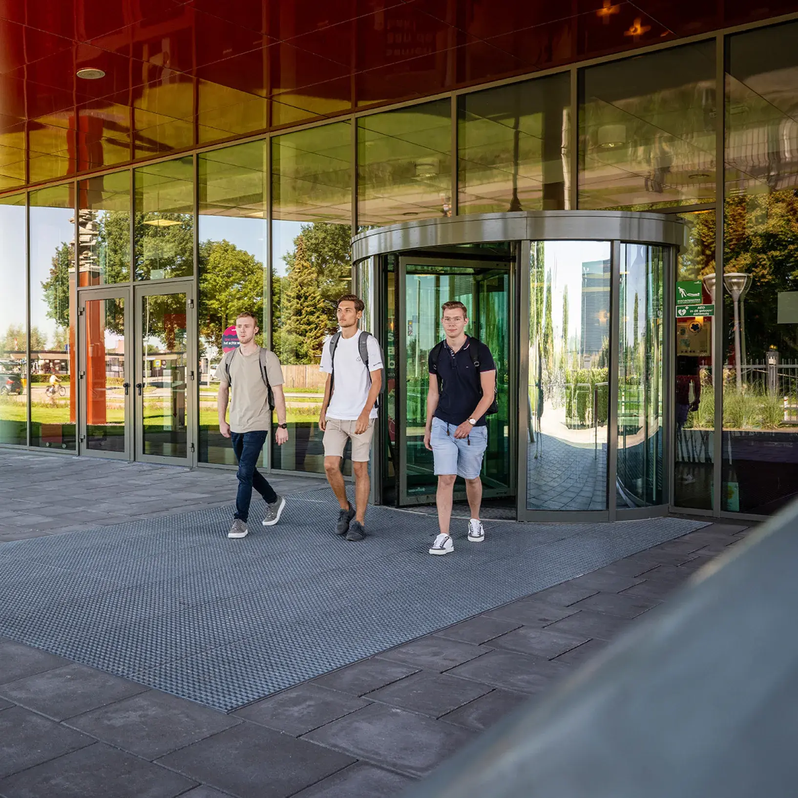 Drie studenten voor schoolgebouw