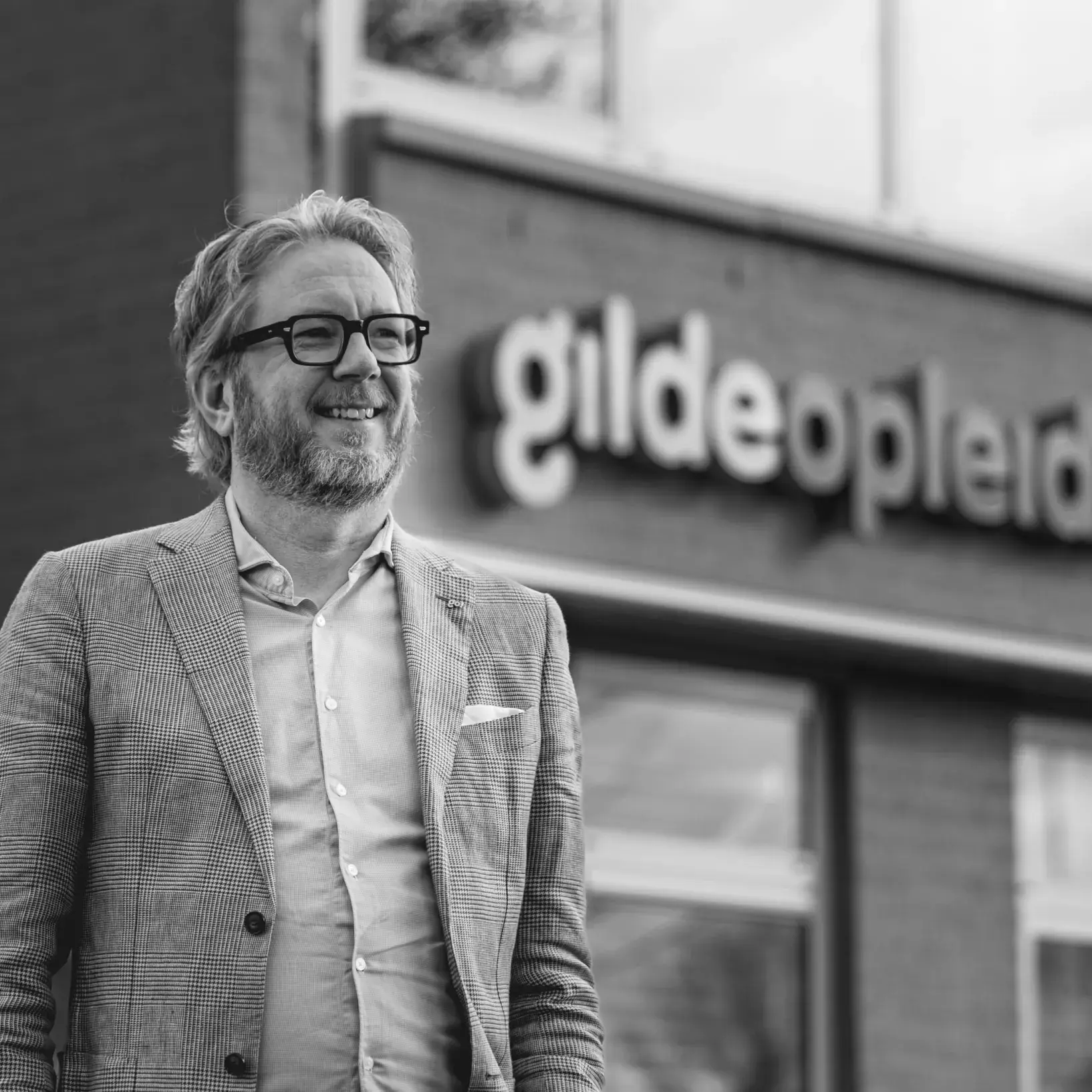 Man voor gebouw Gilde Opleidingen