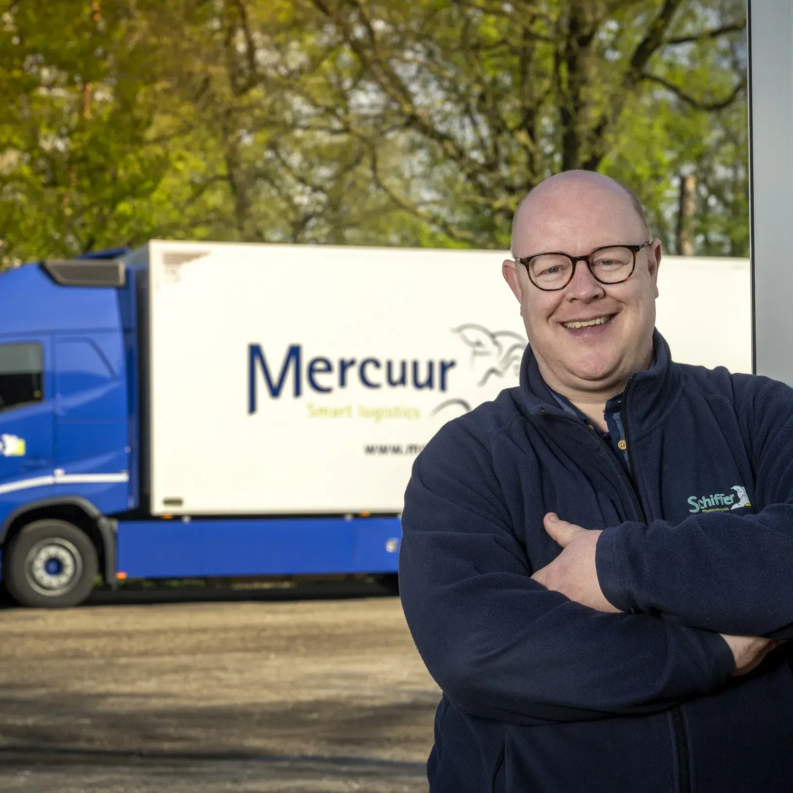 Man poserend voor vrachtwagen Mercuur Smart Logistics
