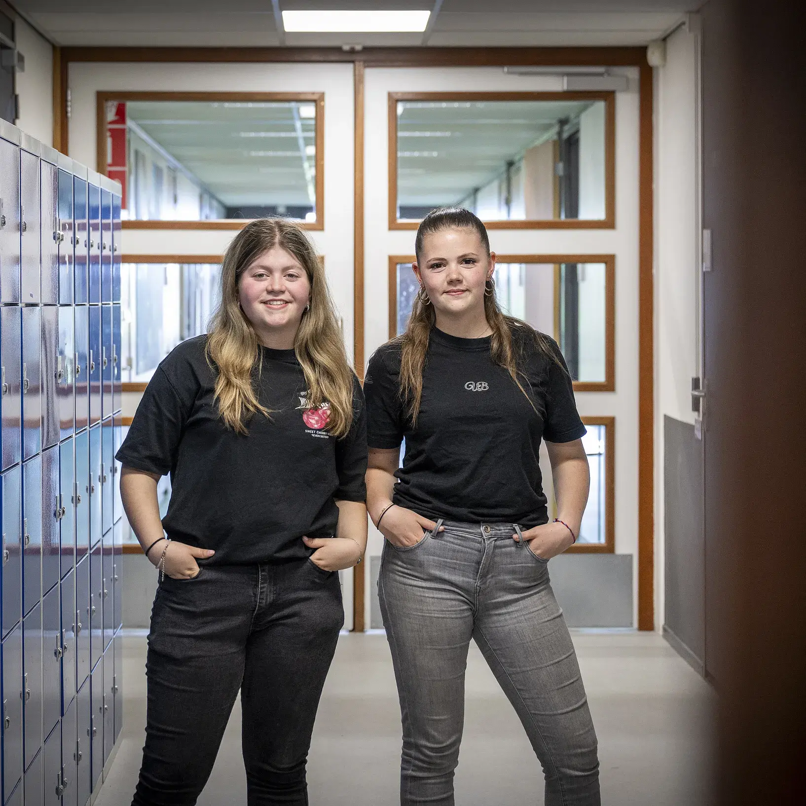 Twee meiden die poseren voor de kluisjes